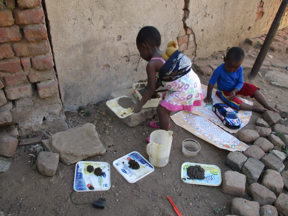 bandile-making-mud-sadza-and-carrying-her-baby